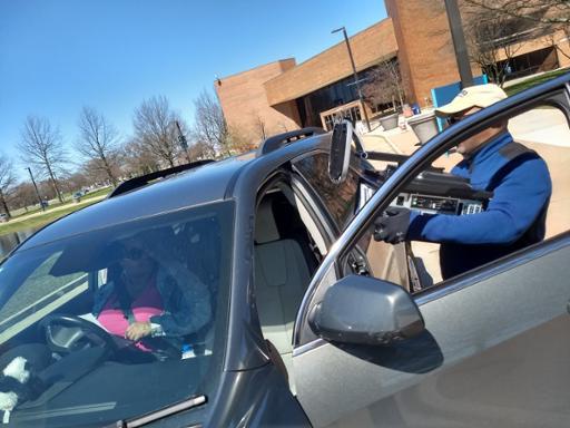 Tri-C staff member loading a computer into a student's car.